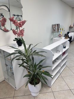 Salon reception desk with built-in retail display shelving.