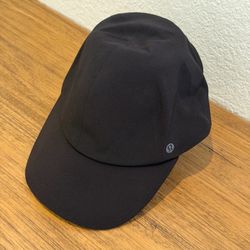 Sleek black athletic cap from lululemon athletica. Lightweight fabric built for movement. Breathable design helps manage moisture. Structured brim off