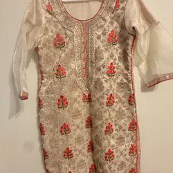 Elegant dress with intricate floral embroidery. Features red and gold accents on a cream base.