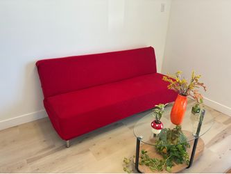 Royal blue futon armless sofa, cones with a red and orange slip cover