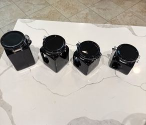 Set of glossy black ceramic canisters.
