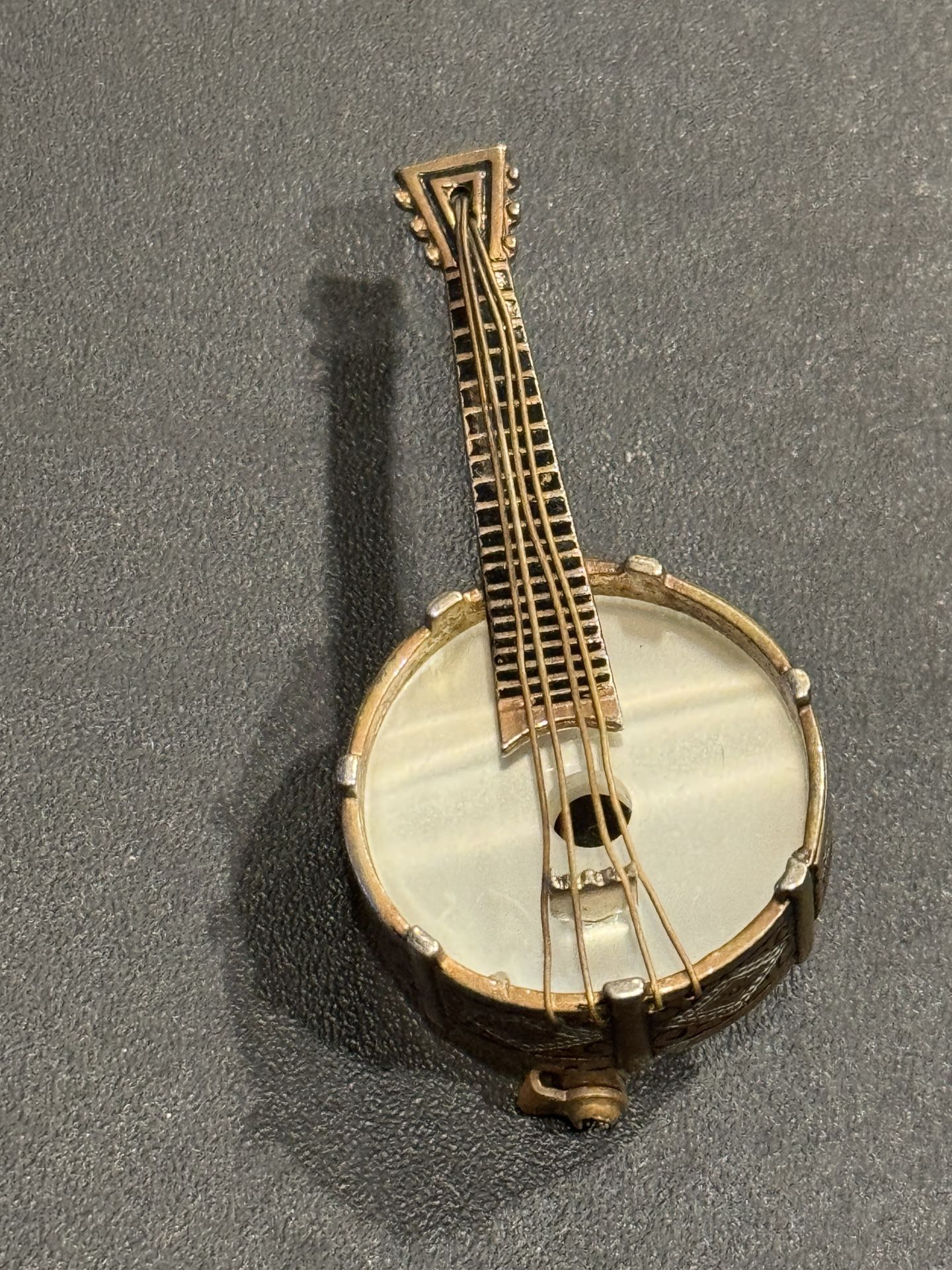 Vintage Banjo Brooch Damascene Style Gold Tone String Instrument Lapel Pin. Mother of Pearl banjo head. Made in Spain. Approximately 2” long.