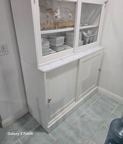 Selling a large white kitchen hutch/ display cabinet with lots of storage.