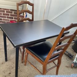 A Small IKEA  Table With Two Old , Strong Leather, And Wood Chairs, ( One Chair Has A Little Cut On The Leather Seat)