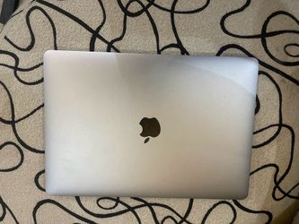 MacBook Pro in Silver, likely a 13-inch model with Touch Bar (2016–2020 generation).