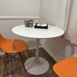 Tulip Table and 2 orange chairs