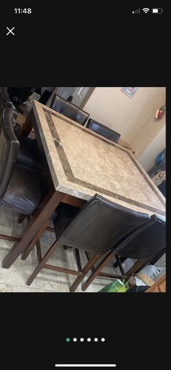 granite  marble high dining table with 8 chairs square 54" x 54" 3" feet high  good condition, the brown buttons came out of 2 chairs as seen in pic