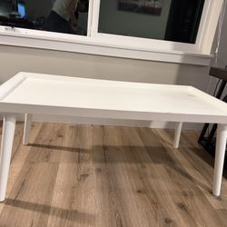 Selling a modern white tray-style table in good condition.