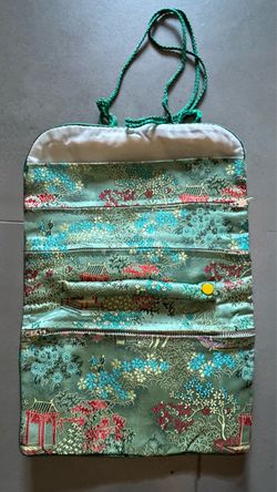 Vintage Asian silk brocade travel jewelry roll organizer featuring a vibrant teal pagoda and floral scenic pattern with multiple zippered compartments