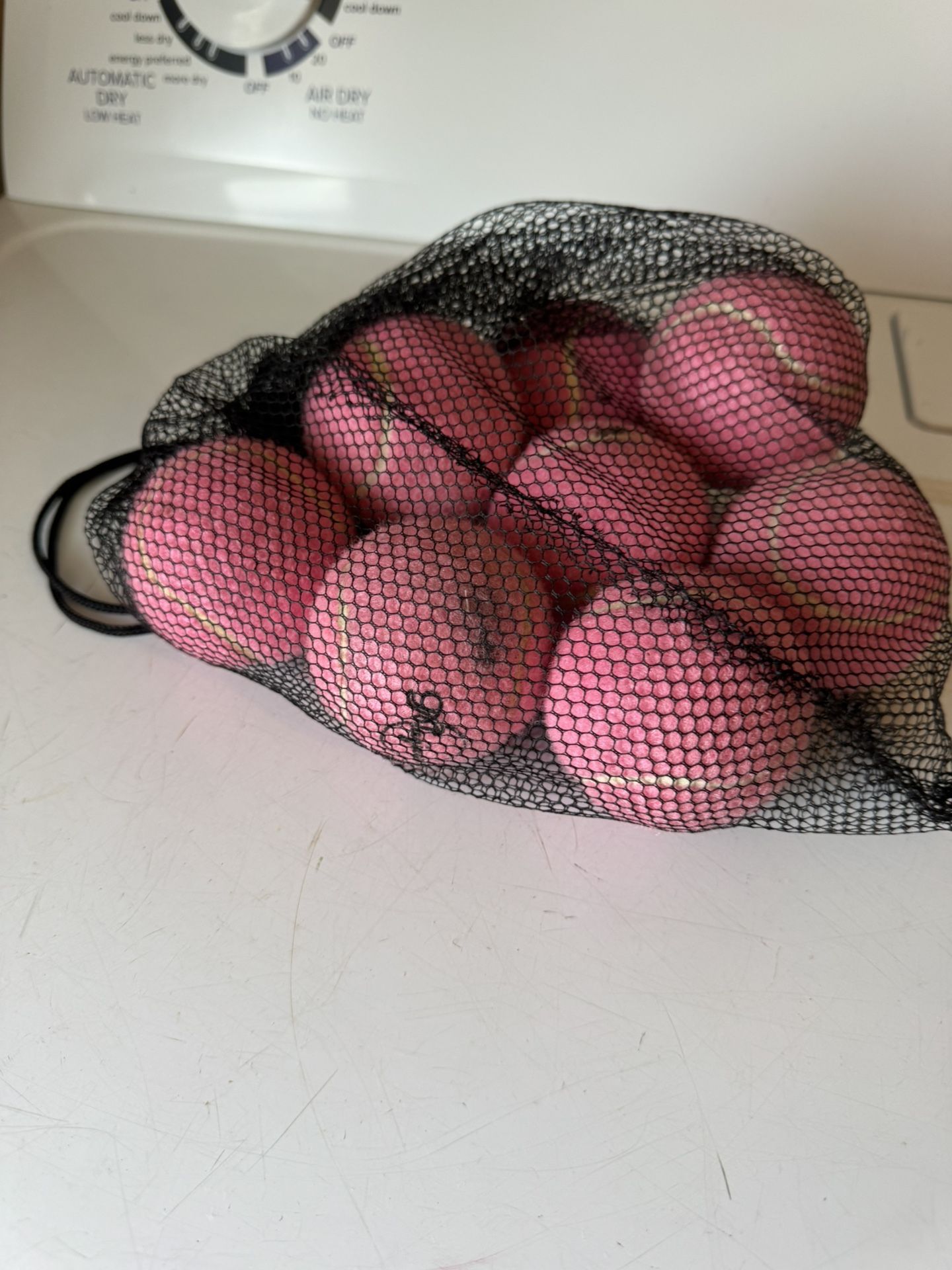 Set of seven brand new pink tennis balls in bag