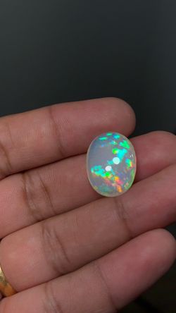 Natural Ethiopian Opal with vibrant play-of-color displaying flashes of green, red, orange, blue, and yellow. This beautiful oval cabochon is perfect 