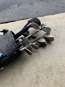 Assorted golf clubs with bag