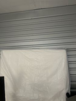 Queen mattress wrapped in mattress cover.