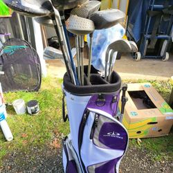 Golf clubs, bag and bucket of balls