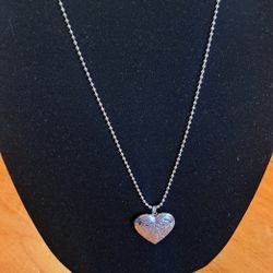 Silver Tone,  With a Charm, I dont Know If the Charm is Copper It has a Little  Scratched  on the back 