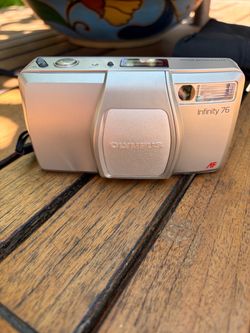 Olympus Infinity 76 35mm compact film camera with a silver-colored body.