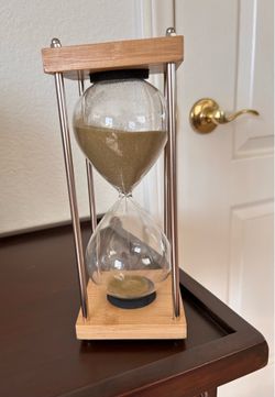 Large 60 minute hourglass with transparent glass and natural oak wood base.