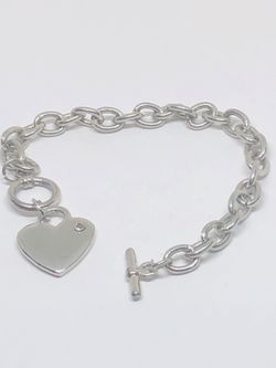 Silver tone bracelet with heart charm with a rhinestone