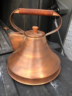 A vintage copper teapot with a wide base