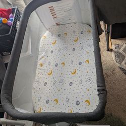 Baby delight beside bassinet