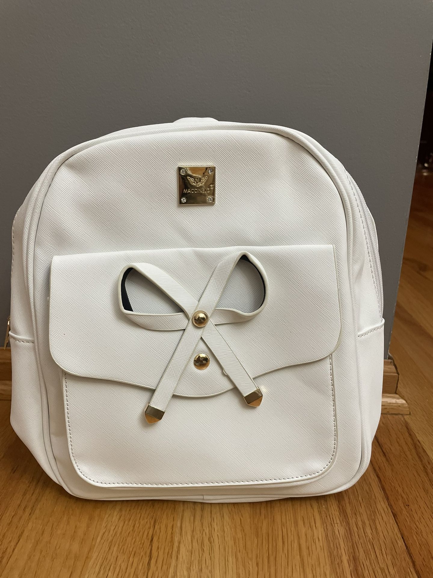 White backpack with tags and a purse with wallet and removable keychain