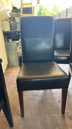 Elegant beige leather dining chair with wooden legs. Comfortable and stylish design.