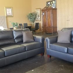 Dark brown faux leather sofa and loveseat with pinheads