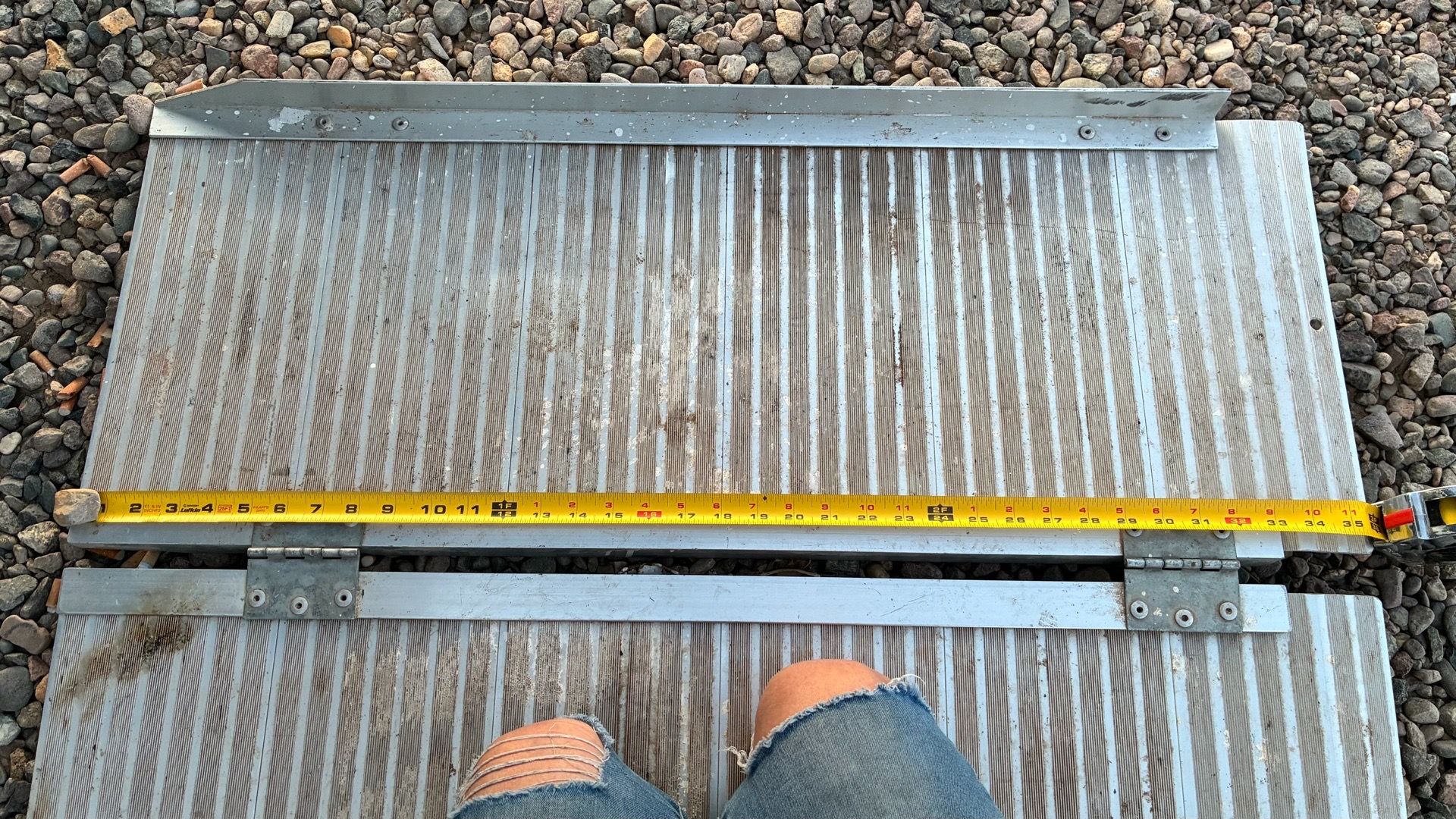 portable folding aluminum ramp approximately 28โ30 inches wide.