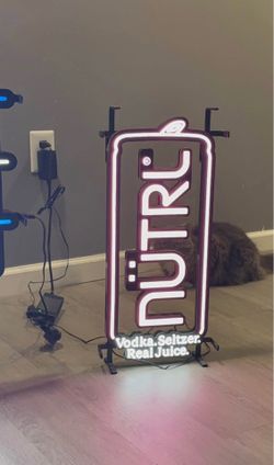 This is a NÜTRL Vodka Seltzer neon sign showcasing a stylized can design for the brand's "Real Juice" product line.