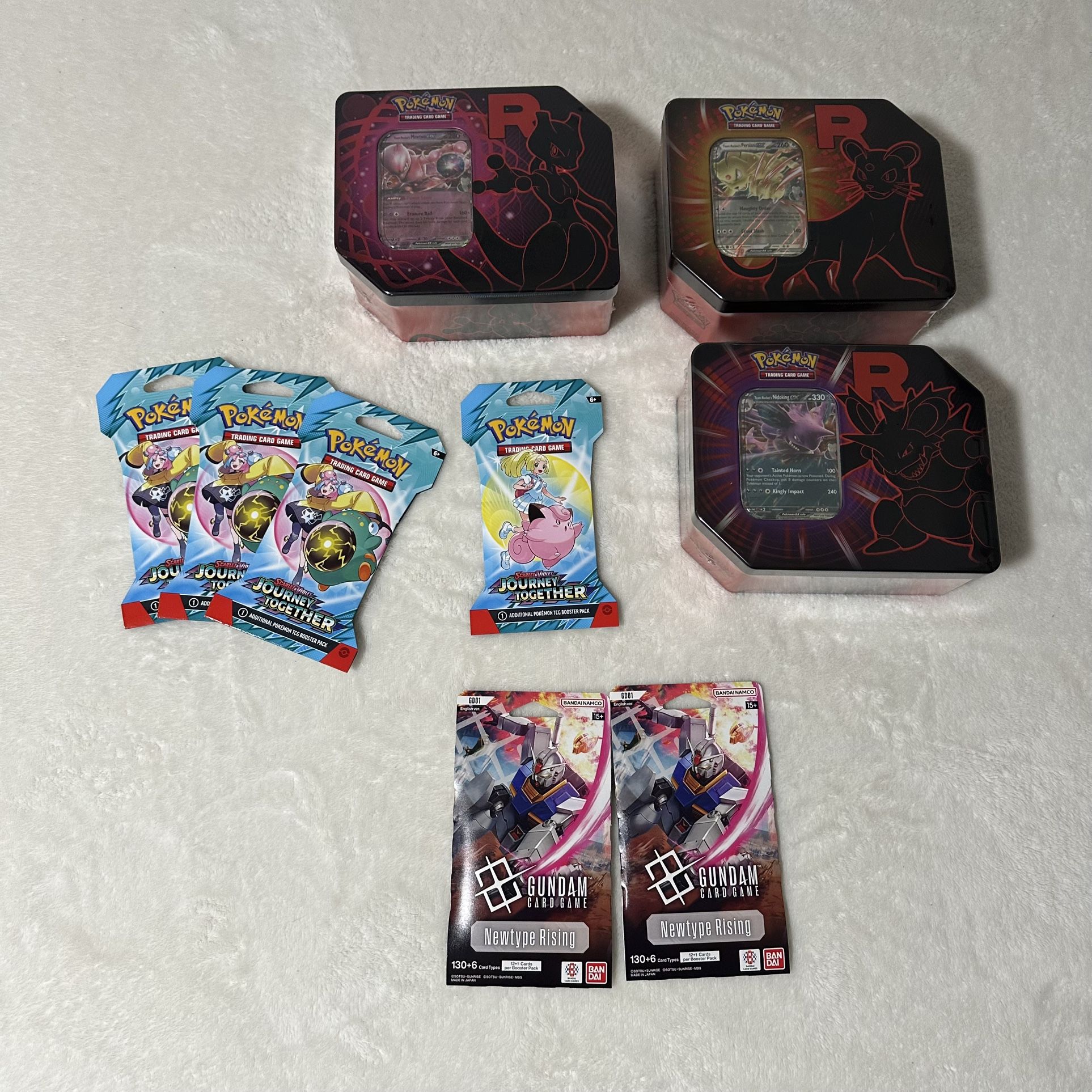 Pokemon Team Rocket tin, Journey together pack, and Gundam Card game pack