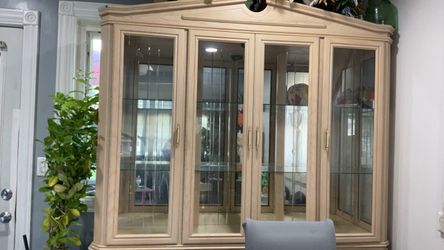 large, light-wood china cabinet and hutch with glass-front display doors and lower storage drawers