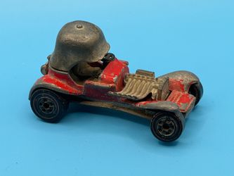 1969 Hot Wheels Redline Red Baron die-cast car, featuring a distinct red body and a prominent German-style helmet helmet.