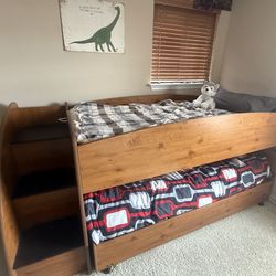 Twin bunk beds with built in dresser and staircase