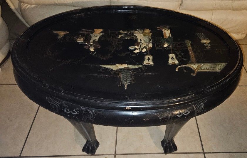 Oval coffee table with intricate Asian-themed design. 43” length, 30” wide. 6 stools that fit under table Cabinet32wide29”high13”depth.Chinese Table