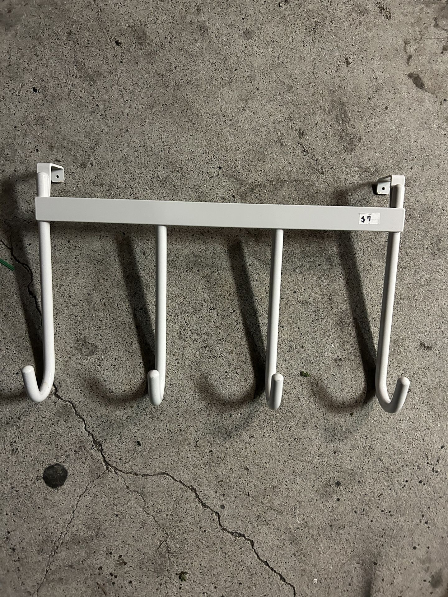 white metal over-the-door or under-shelf hanging rack with four hooks