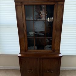 Antique wooden hutch or display cabinet with glass and solid doors.