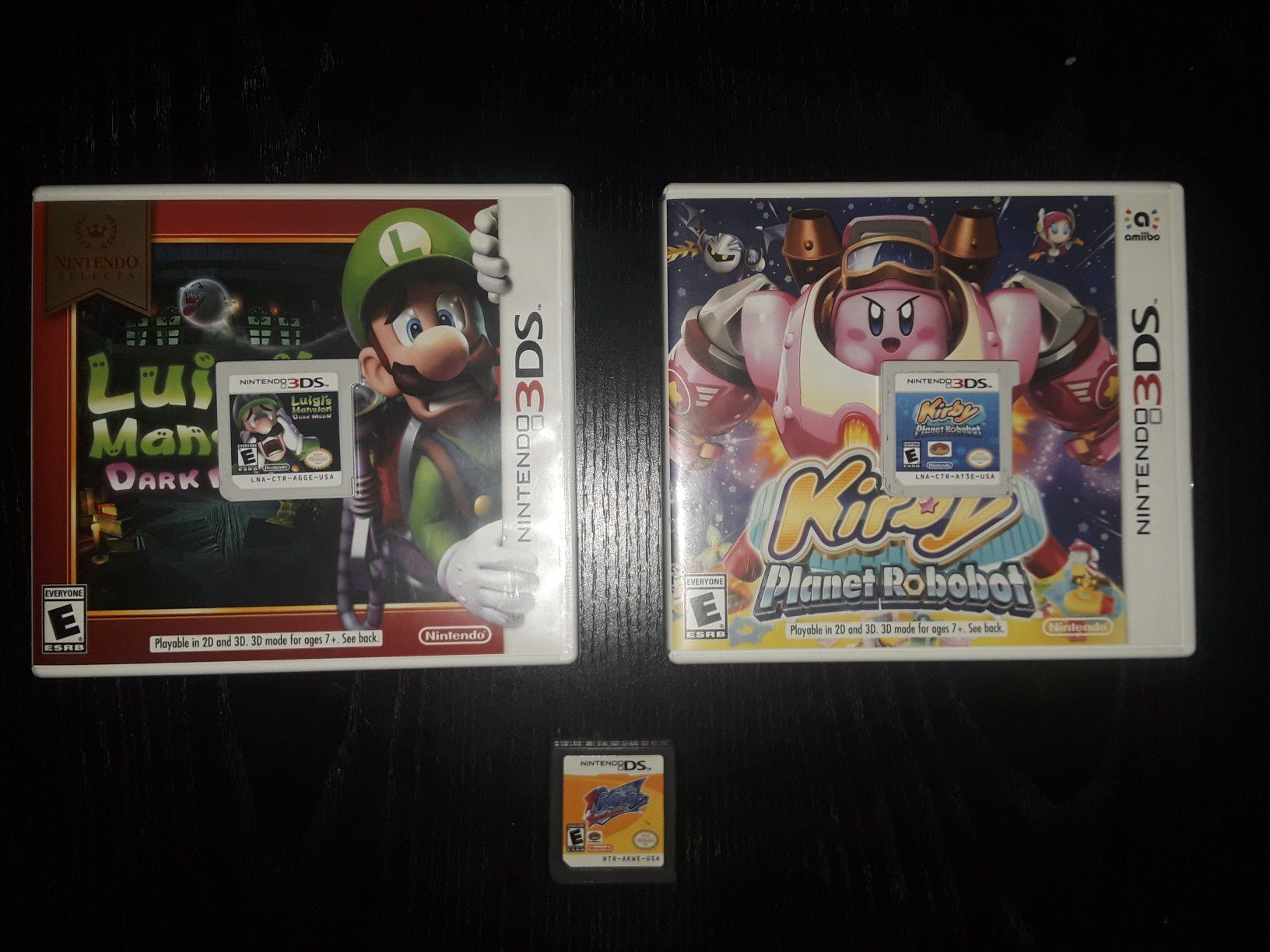 3 Nintendo 3ds games: Luigi's Mansion Dark Moon, Kirby Planet Robot, and Kirby Squek Squad.