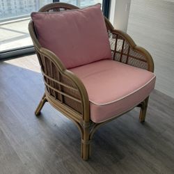 2 rattan lounge chais with pink cushions.
