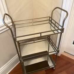 This is a World Market 3-Tier Metal + Glass Bar Cart Gold