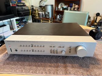 The Vintage Harman Kardon HK725 Stereo Pre-Amplifier in Silver is a high-quality audio device manufactured in Japan. With its sleek design and brand r