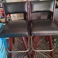 A Pair Of Black And Brown Swivel  With Metal Foot Rest