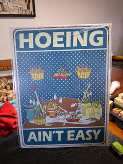Large metal sign. "Hoeing Ain't  Easy"