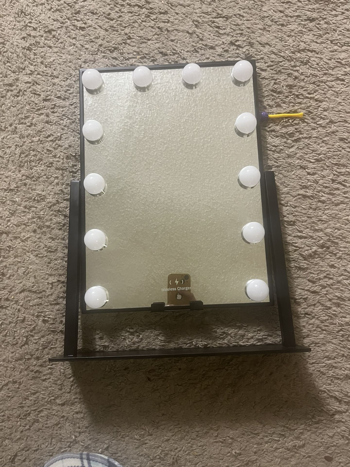 LED light-up makeup mirror with a wireless charging pad. Size 16 by 12 inches