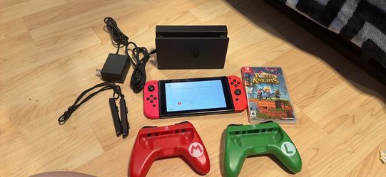 Nintendo switch with docking station, charger, wrist straps, two joy, con holders, and portal Knights game