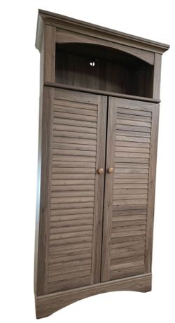 Sauder Harbor View storage cabinet in a salt oak finish with louver-detailed doors