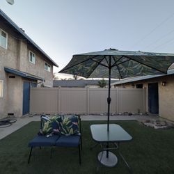 Outdoor patio table and patio bench with umbrella and stand. 