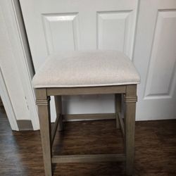 Wooden stool with upholstered cushion