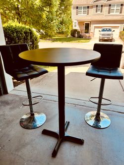Pub table with two adjustable leather chairs.