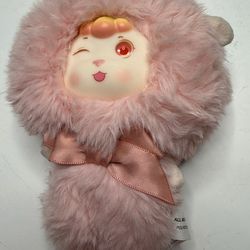 The toy depicts a lamb featuring fluffy fur, a vinyl face, and a satin bow. This specific character is portrayed winking. Functionality: The model can