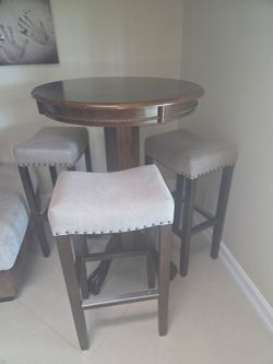 Brown round table with 3 stools